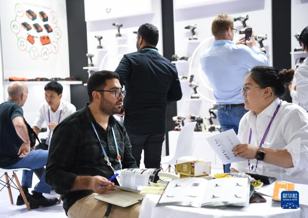 10月15日，在一家電動工具展臺，外國采購商在洽談業(yè)務(wù)。新華社記者 鄧華 攝