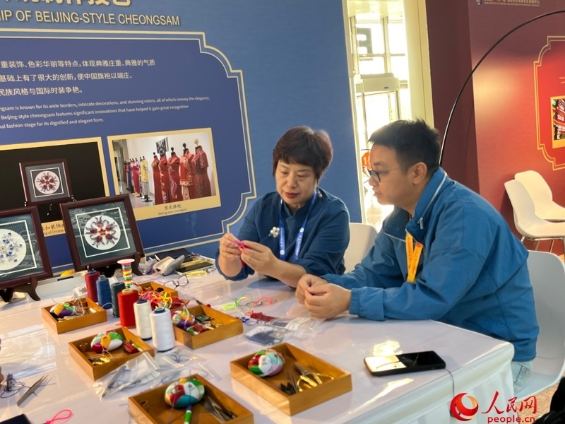 記者在新聞中心非遺傳承人展區(qū)進(jìn)行體驗(yàn)。人民網(wǎng)記者 杜燕飛攝