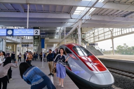  10月17日，在印度尼西亞萬隆德卡魯爾站，乘客在站臺上和雅萬高鐵高速動車組列車合影。新華社記者 徐欽 攝