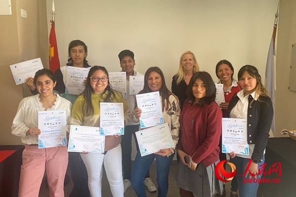 社區(qū)工作專(zhuān)家莫伊拉（后排右二）向“中文工坊”第二期培訓(xùn)班部分結(jié)業(yè)學(xué)員頒發(fā)由薩爾塔省教育部簽發(fā)的結(jié)業(yè)證書(shū)。人民網(wǎng)記者 吳思萱攝