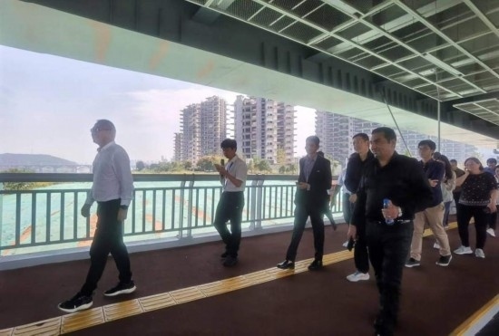 10月24日，2023“一帶一路”媒體合作論壇聯合采訪團團員走在清水塘大橋景觀通道上。本報記者 常雯宜攝