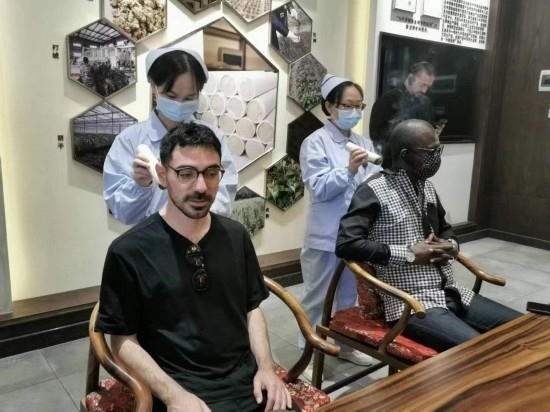 2023“一帶一路”媒體合作論壇聯(lián)合采訪團(tuán)團(tuán)員在九牛草展示館體驗(yàn)艾灸。（本報(bào)記者 黃超攝）