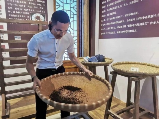 2023“一帶一路”媒體合作論壇聯(lián)合采訪團(tuán)團(tuán)員在非遺文化展示館體驗(yàn)中藥炮制技藝。（本報(bào)記者 黃超攝）