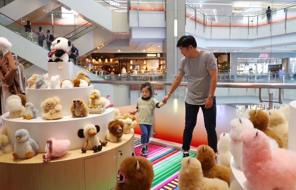 2023年11月2日，顧客在溫暖駝品牌專柜內(nèi)選購。連續(xù)六年參加進(jìn)博會(huì)的秘魯羊駝制品品牌溫暖駝在上海市中心商場(chǎng)開設(shè)了專柜。新華社記者 方喆 攝