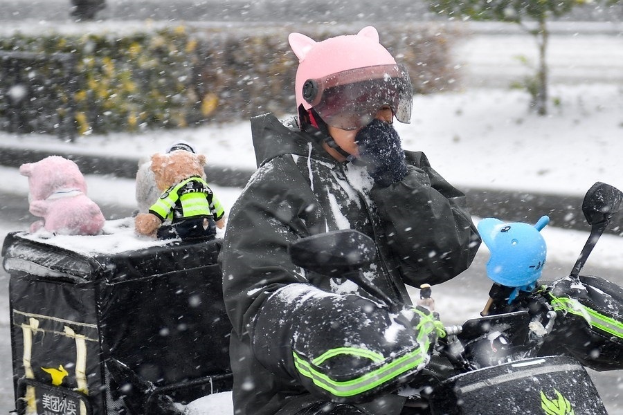 11月6日，在長(zhǎng)春市街頭，一名外賣員在雪中騎行。新華社記者 許暢 攝