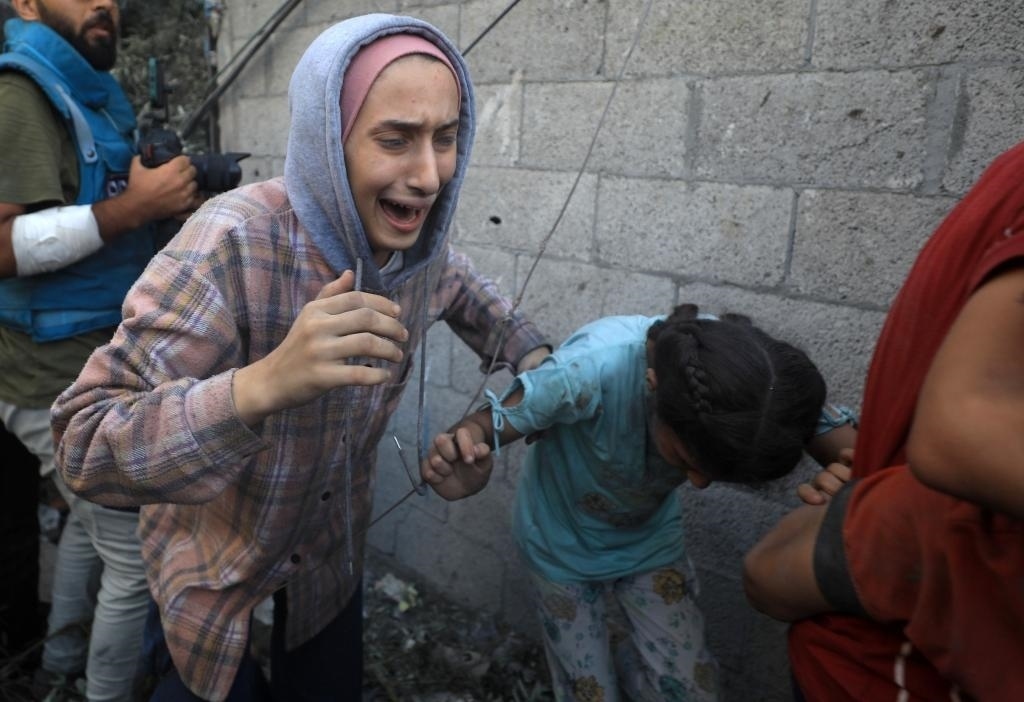 11月6日，人們從加沙地帶中部地區(qū)一處被炸難民營逃離。新華社發(fā)（亞西爾·庫迪攝）