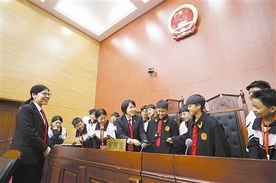 圖③：同學們穿法袍、敲法槌，爭做“小法官”。