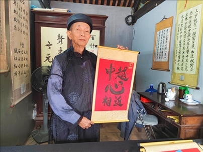 越南首都河內(nèi)文廟內(nèi)，阮明珠展示“中越心相近”書法作品。
