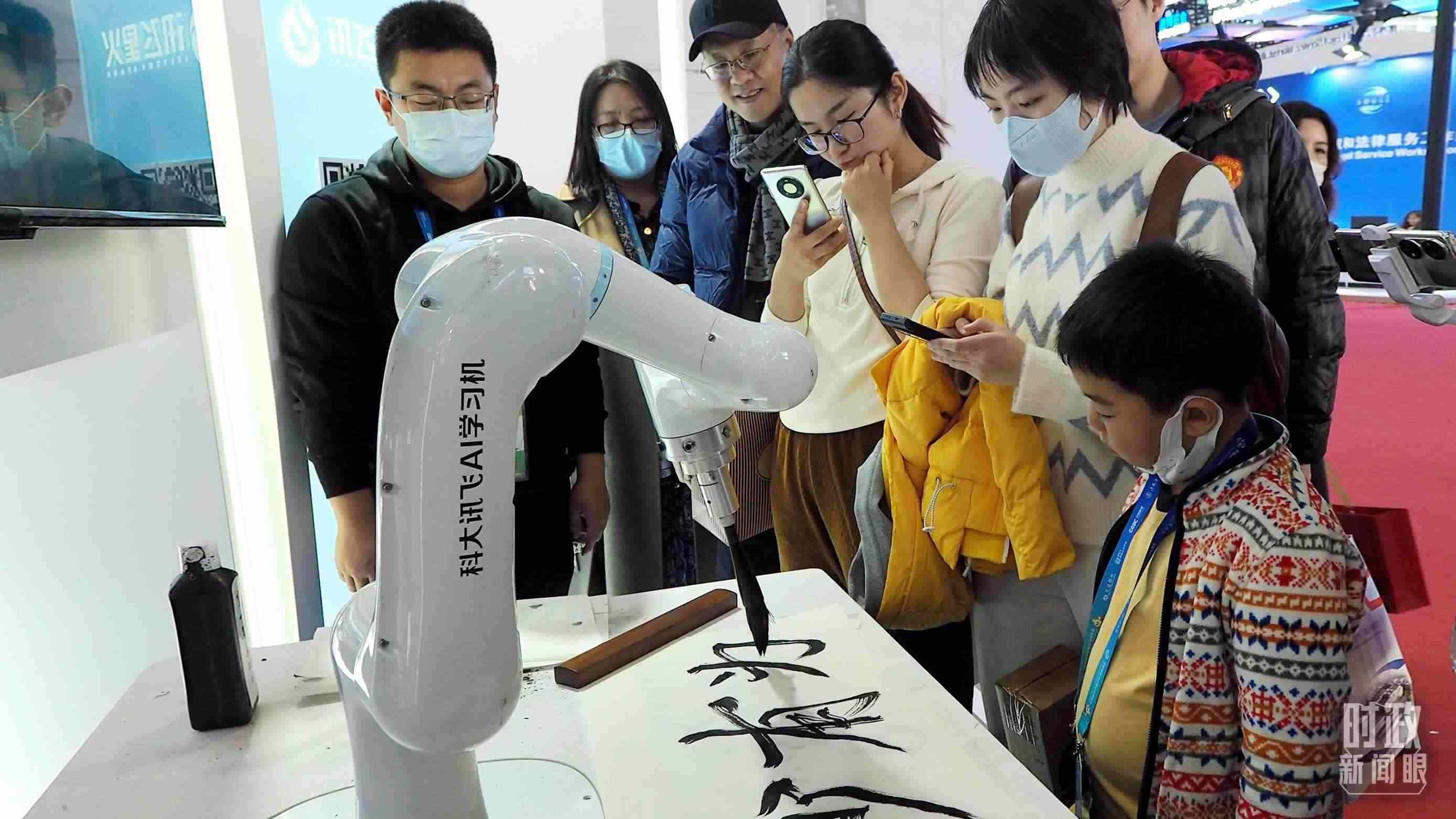 △觀眾在首屆鏈博會(huì)上體驗(yàn)AI書法機(jī)器人。