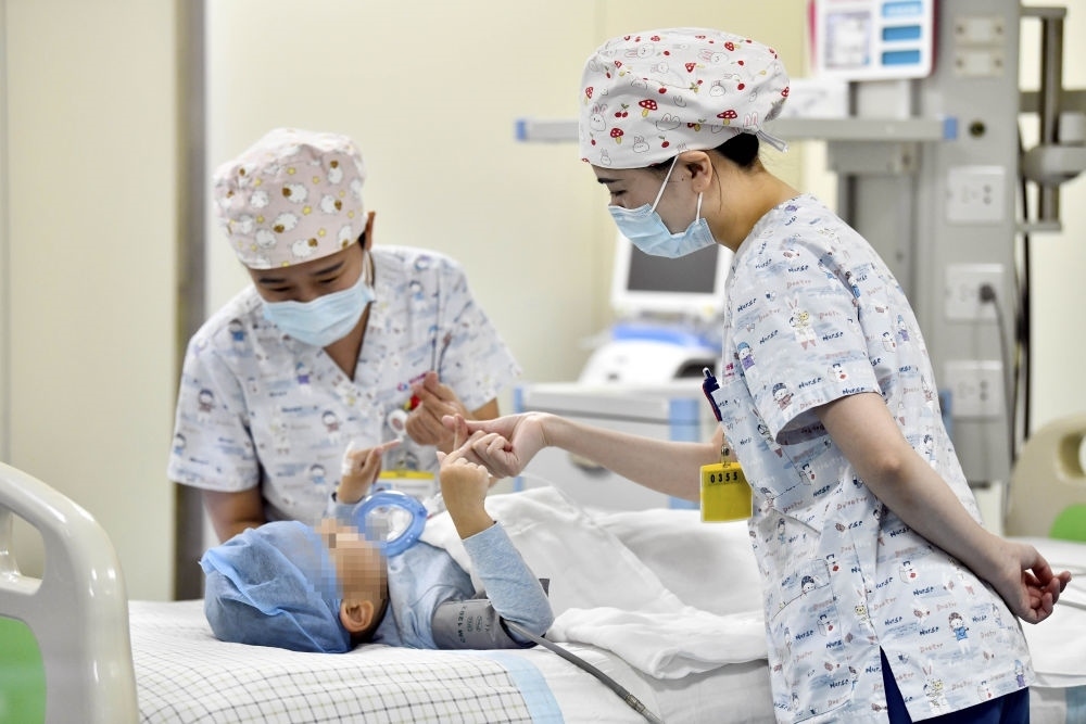 在山東省棗莊市婦幼保健院兒童ICU病房，醫(yī)護(hù)人員為完成靶向治療藥物諾西那生鈉的4歲脊髓性肌萎縮癥患兒加油鼓勁（2022年1月1日攝）。諾西那生鈉注射液是我國(guó)首個(gè)獲批治療脊髓性肌萎縮癥的進(jìn)口藥物，2019年進(jìn)入中國(guó)市場(chǎng)時(shí)，每針價(jià)格近70萬(wàn)元。在2021年國(guó)家醫(yī)保目錄藥品談判中，以3.3萬(wàn)元每針的價(jià)格進(jìn)入新版醫(yī)保藥品目錄。新華社記者 郭緒雷 攝