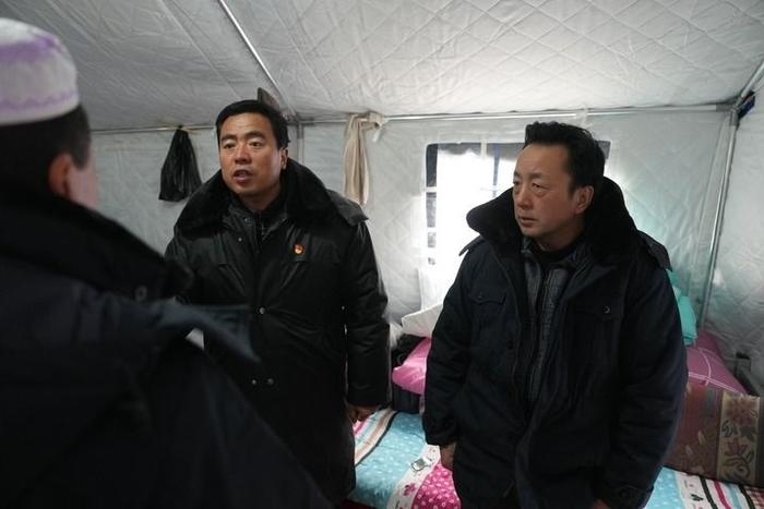 2023年12月22日，積石山縣大河家鎮(zhèn)大河村黨支部書記馬成忠（右二）在帳篷里和受災(zāi)群眾交流。新華社記者 陳斌 攝