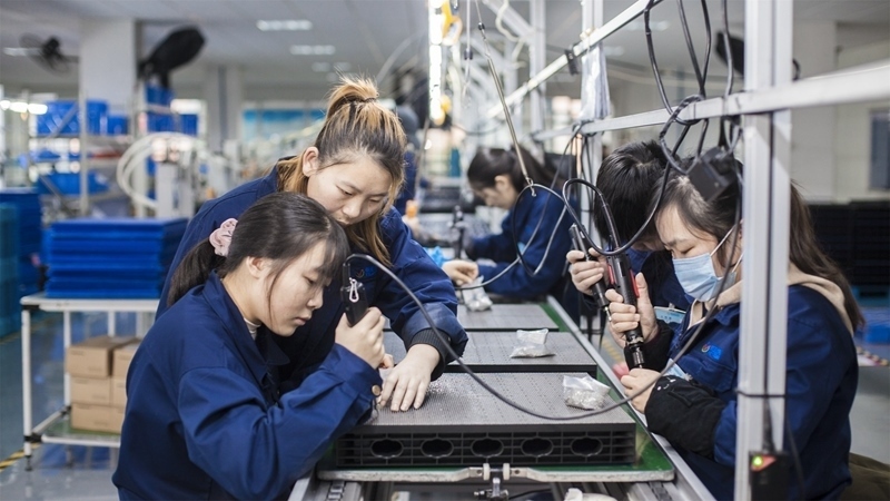 在新亞勝光電的產(chǎn)品線上，工人正進(jìn)行產(chǎn)品組建和安裝布線。受訪者供圖