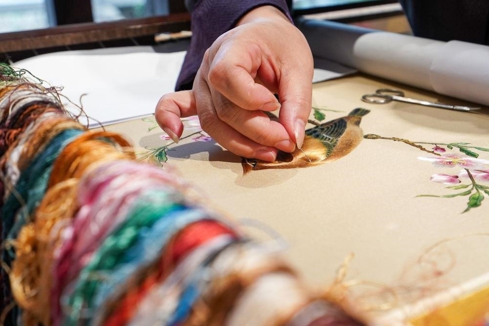 △2023年7月6日，盧建英在江蘇蘇州平江路的工作室內(nèi)刺繡。