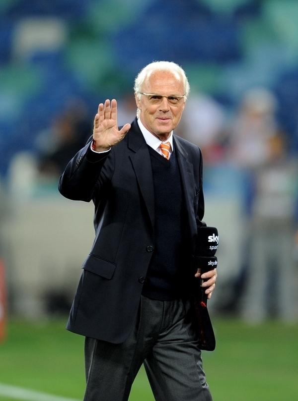 這是2010年7月7日，在南非德班舉行的2010年足球世界杯德國隊對陣西班牙隊的半決賽前，貝肯鮑爾接受電視臺采訪時和友人打招呼。新華社記者 王毓國 攝