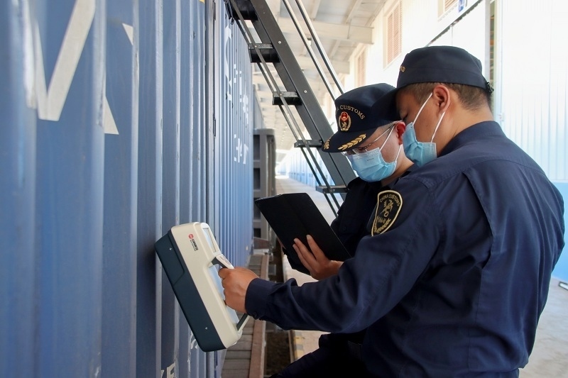 海關(guān)關(guān)員使用手持式輻射探測儀對中老鐵路入境貨物進(jìn)行檢測。張釋巍攝