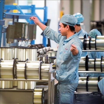 在位于武漢的長(zhǎng)飛光纖光纜股份有限公司光纖生產(chǎn)車(chē)間內(nèi)，工作人員對(duì)光纖進(jìn)行檢測(cè)（資料圖片）。肖藝九攝/本刊