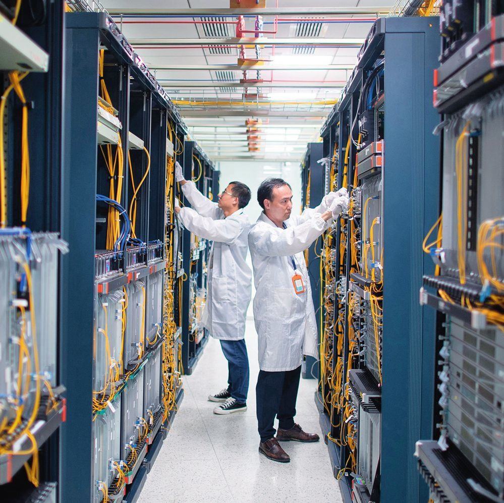 在位于武漢中國(guó)光谷的光電器件研發(fā)制造商——武漢光迅科技股份有限公司生產(chǎn)車(chē)間內(nèi)，技術(shù)人員在光模塊生產(chǎn)線作業(yè)（2023年4月11日攝）。程敏攝/本刊