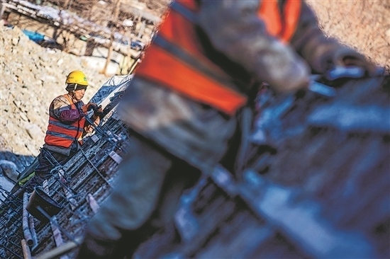 1月3日，房山區(qū)，工人正在雙泉河修筑堤壩。