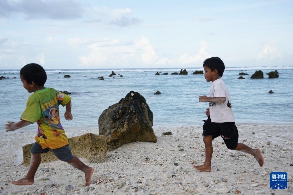 1月20日，兒童在瑙魯海邊嬉戲。新華社記者 王申 攝