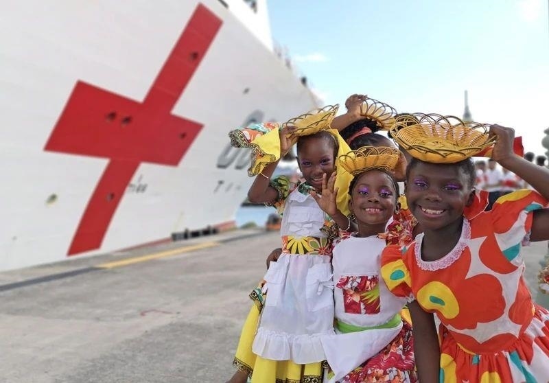 2018年10月，在安提瓜和巴布達首都圣約翰，當?shù)匦∨笥焉泶﹤鹘y(tǒng)服裝歡迎中國海軍“和平方舟”醫(yī)院船首次到訪。