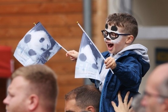  2023年7月26日，在法國(guó)圣艾尼昂市博瓦勒野生動(dòng)物園外，一名兒童等待送別熊貓“圓夢(mèng)”。新華社記者 高靜 攝