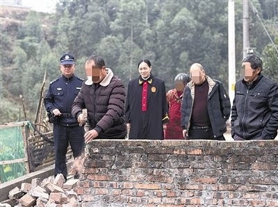  圖③：庭審結(jié)束后，在法官的見證下，陳某在院壩邊重新開鑿一條通道。