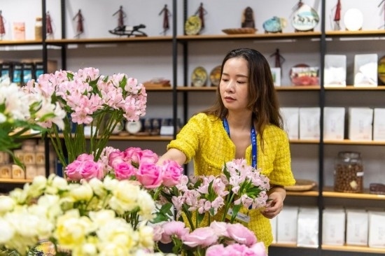 2023年7月1日，在位于湖南省長沙市的湖南高橋大市場，中非經(jīng)貿(mào)博覽會常設(shè)展館展區(qū)肯尼亞館工作人員在整理產(chǎn)自非洲的鮮花。新華社記者 陳思汗 攝