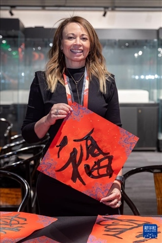 1月28日，在上海豫園舉行的民俗活動(dòng)上，美國(guó)馬斯卡廷初中校長(zhǎng)珍妮弗·李·弗里德利展示自己寫(xiě)下的“?！弊?。 新華社記者 王翔 攝