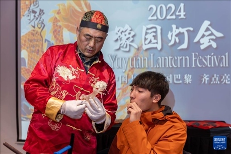 1月28日，在上海豫園舉行的民俗活動(dòng)上，美國(guó)馬斯卡廷中學(xué)學(xué)生在非遺傳承人的指導(dǎo)下吹糖偶。 新華社記者 王翔 攝