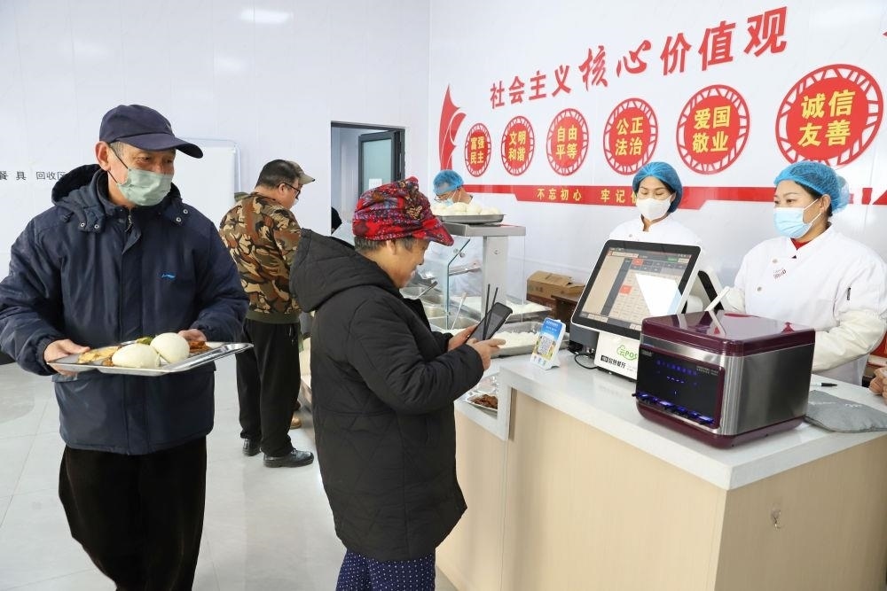 △2024年2月1日，市民在河北涿州市雙塔街道永濟(jì)秀園小區(qū)便民食堂內(nèi)購買午餐。