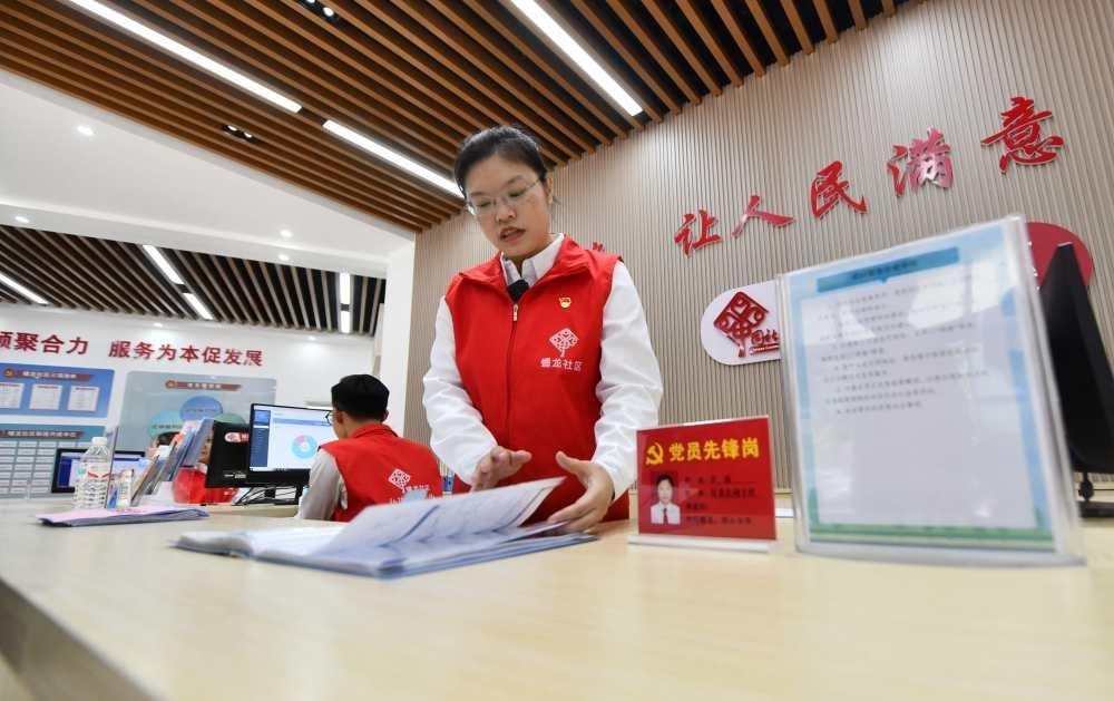 △2023年12月14日，廣西南寧市蟠龍社區(qū)，工作人員在為居民服務(wù)。