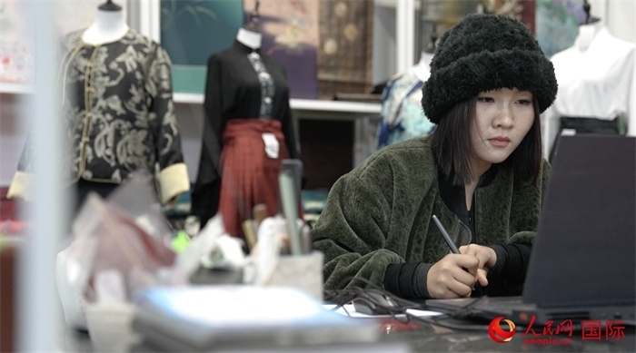 1月23日，在山東省菏澤市曹縣有愛云倉直播基地，張子晨正在設(shè)計漢服。 人民網(wǎng)記者 袁蒙攝