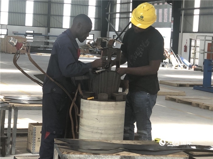 經(jīng)貿(mào)合作區(qū)廠房內(nèi)，當(dāng)?shù)毓と苏诰o張作業(yè)。人民網(wǎng)記者 黃培昭攝