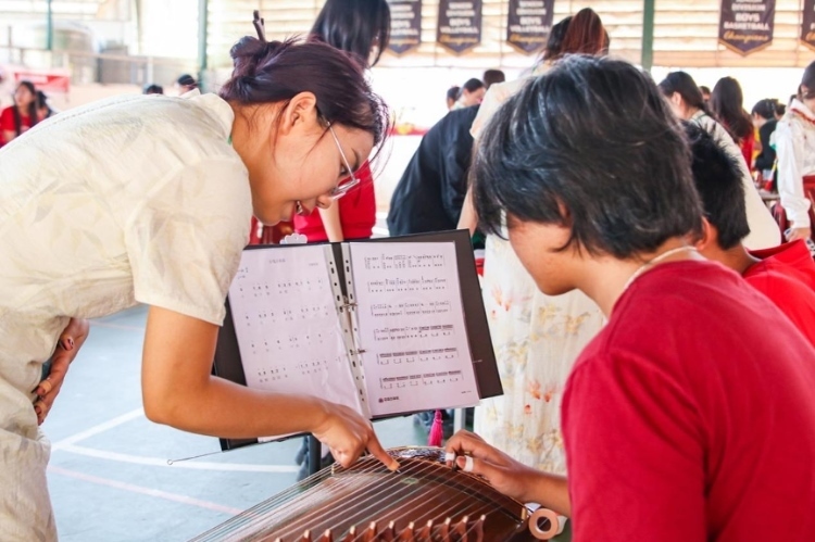 志愿者教師指導(dǎo)學(xué)生彈奏古箏?；顒?dòng)主辦方供圖