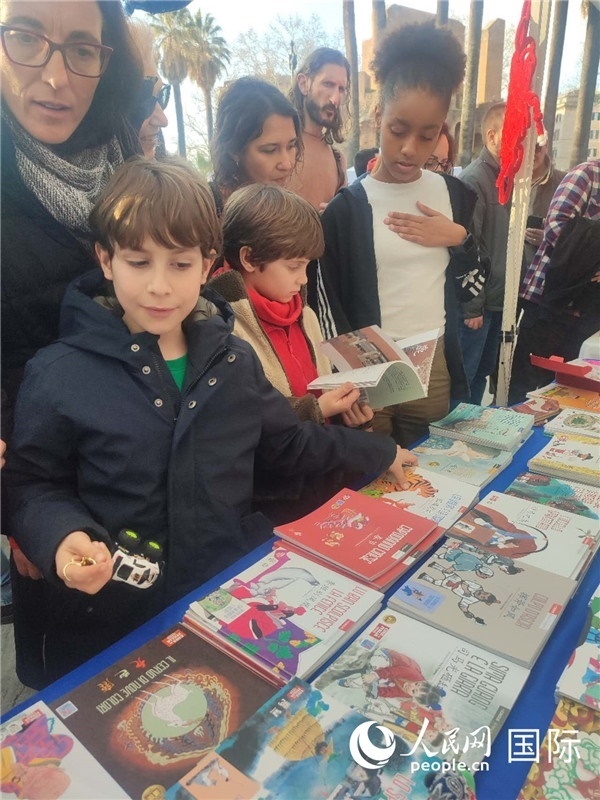 印刷精美的中國傳統(tǒng)文化叢書吸引了小游客的注意。人民網(wǎng)記者鄭彬攝