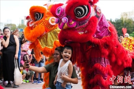 圖為舞獅表演吸引民眾合影。張興龍攝