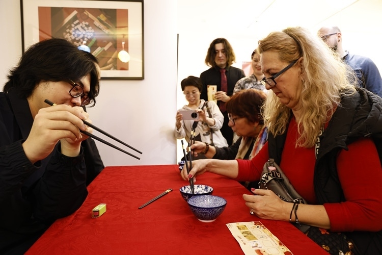 羅馬尼亞觀眾體驗用筷子夾花生。中國文化中心供圖