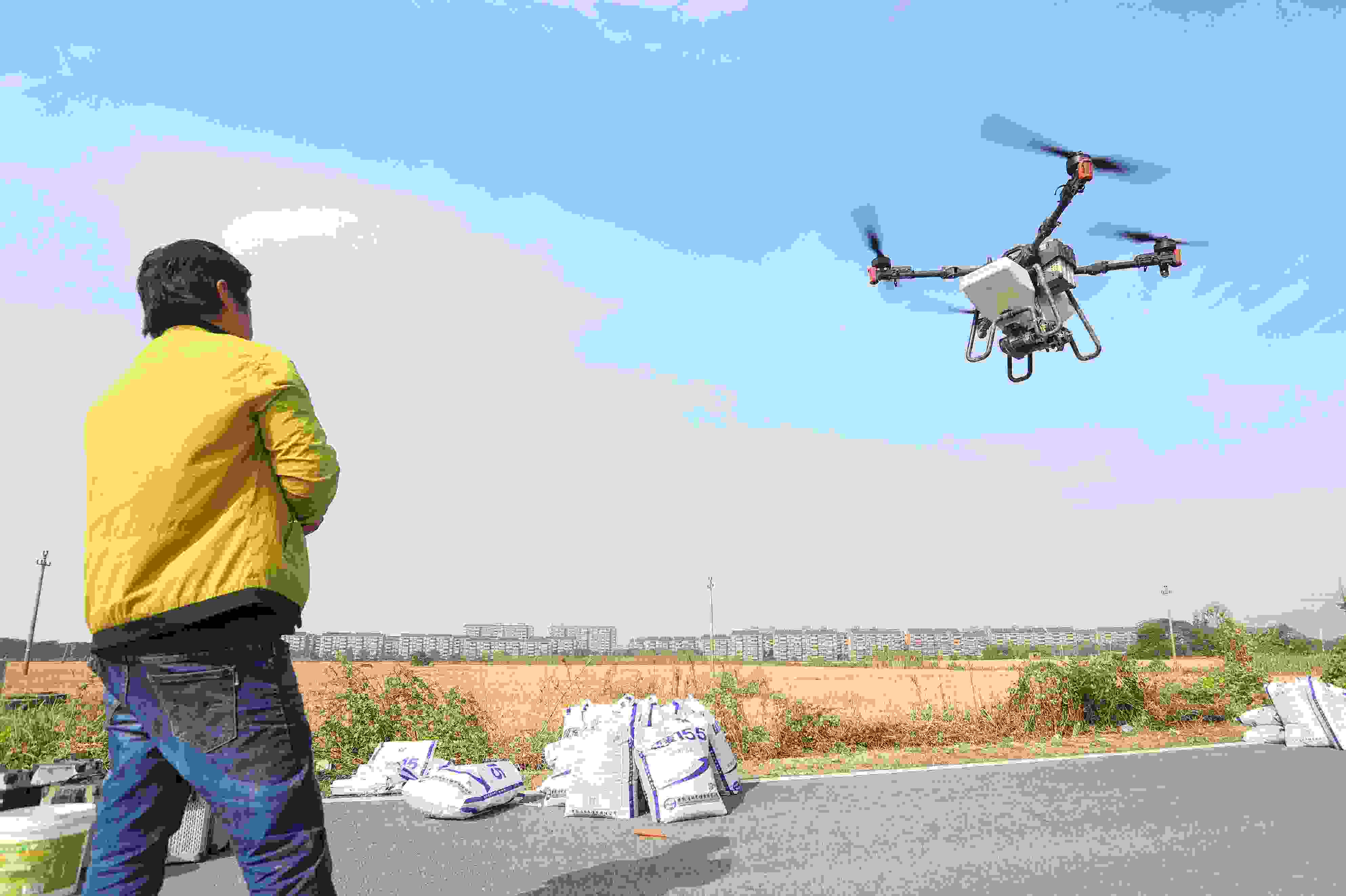 2023年11月15日，浙江嘉興，南湖區(qū)七星街道一處農(nóng)田里，農(nóng)民操縱無人機進行冬小麥飛播。