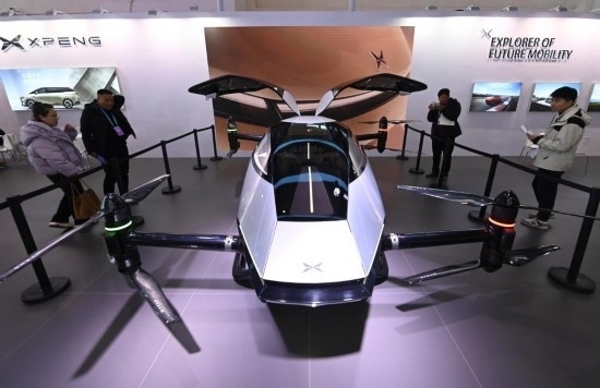 2023年12月1日，在鏈博會智能汽車鏈展區(qū)小鵬汽車展臺，參觀者觀看一臺智能飛行器。新華社記者蔡湘鑫攝