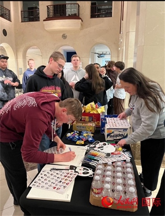 學(xué)生們出發(fā)前紛紛在留言簿留言。人民網(wǎng)記者 鄧圩攝