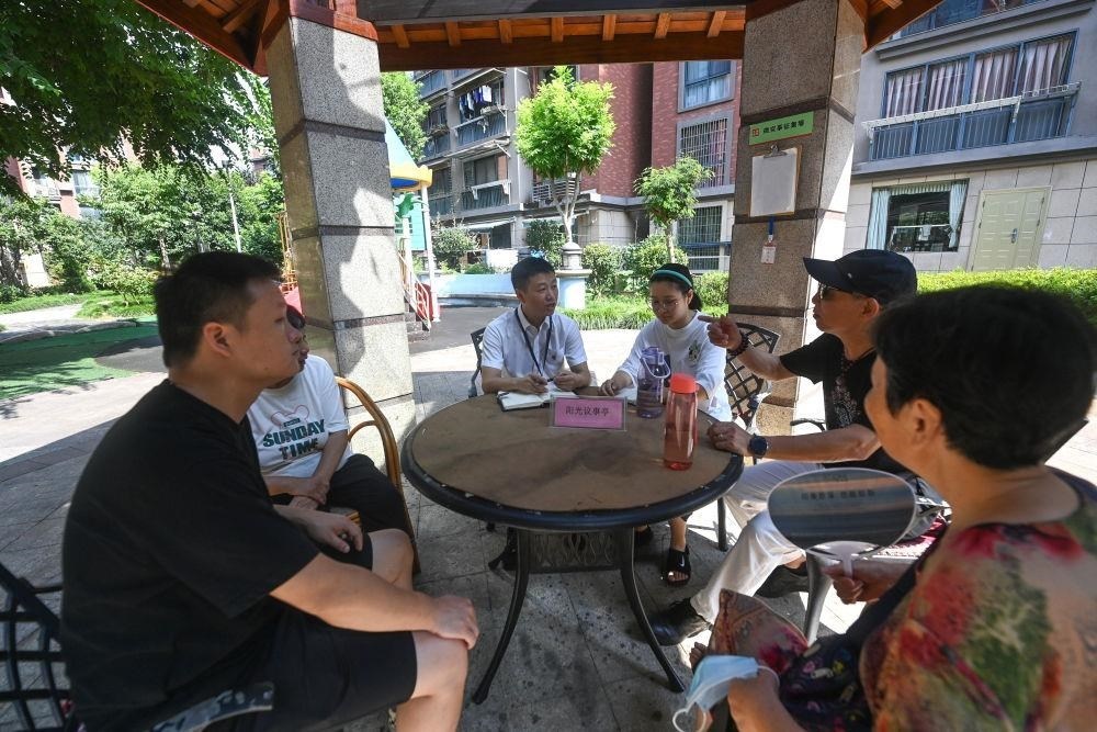 △2023年7月21日，在位于浙江杭州臨安區(qū)錦南街道水岸陽光小區(qū)的陽光議事廳，街道干部在聽取居民們反映的問題及意見。