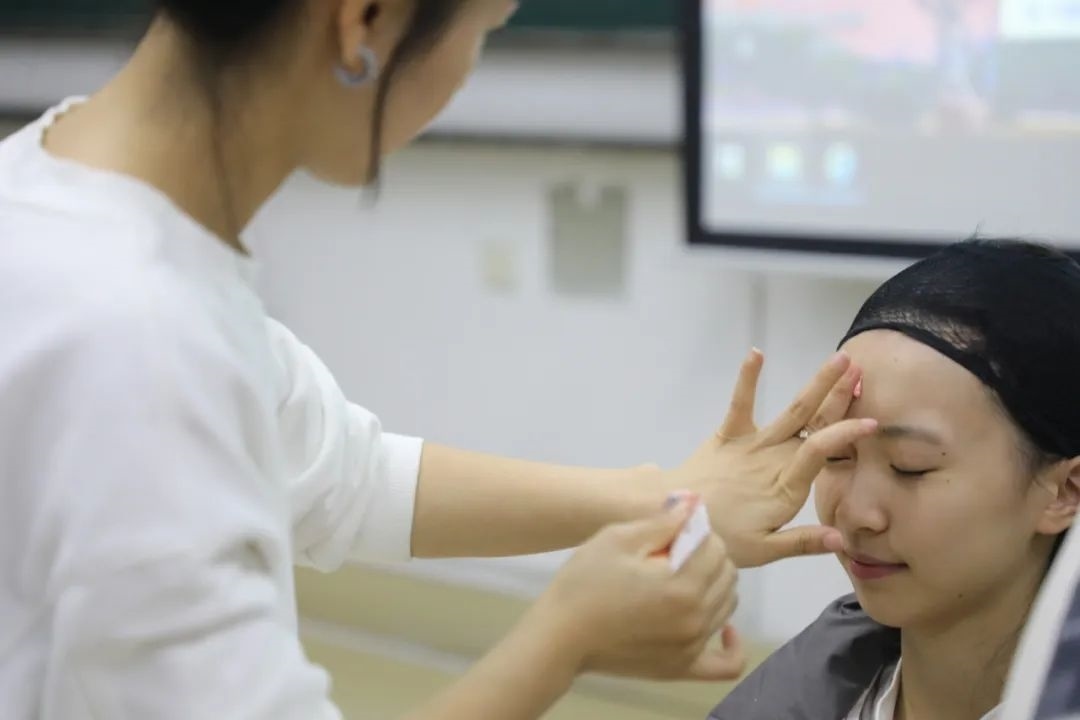 課堂上，一名學(xué)生在體驗(yàn)上戲妝。學(xué)校供圖