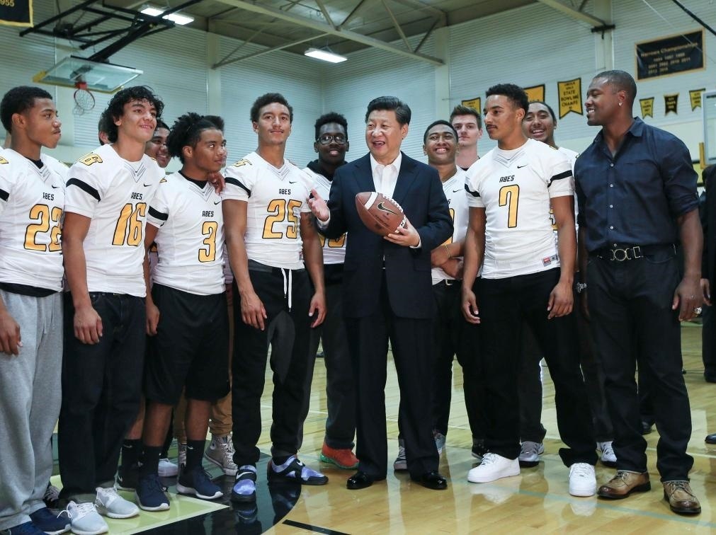 2015年9月23日，國家主席習(xí)近平參觀美國塔科馬市林肯中學(xué)。這是習(xí)近平在學(xué)校體育館，同上橄欖球訓(xùn)練課的學(xué)生們親切交談。新華社記者 蘭紅光 攝