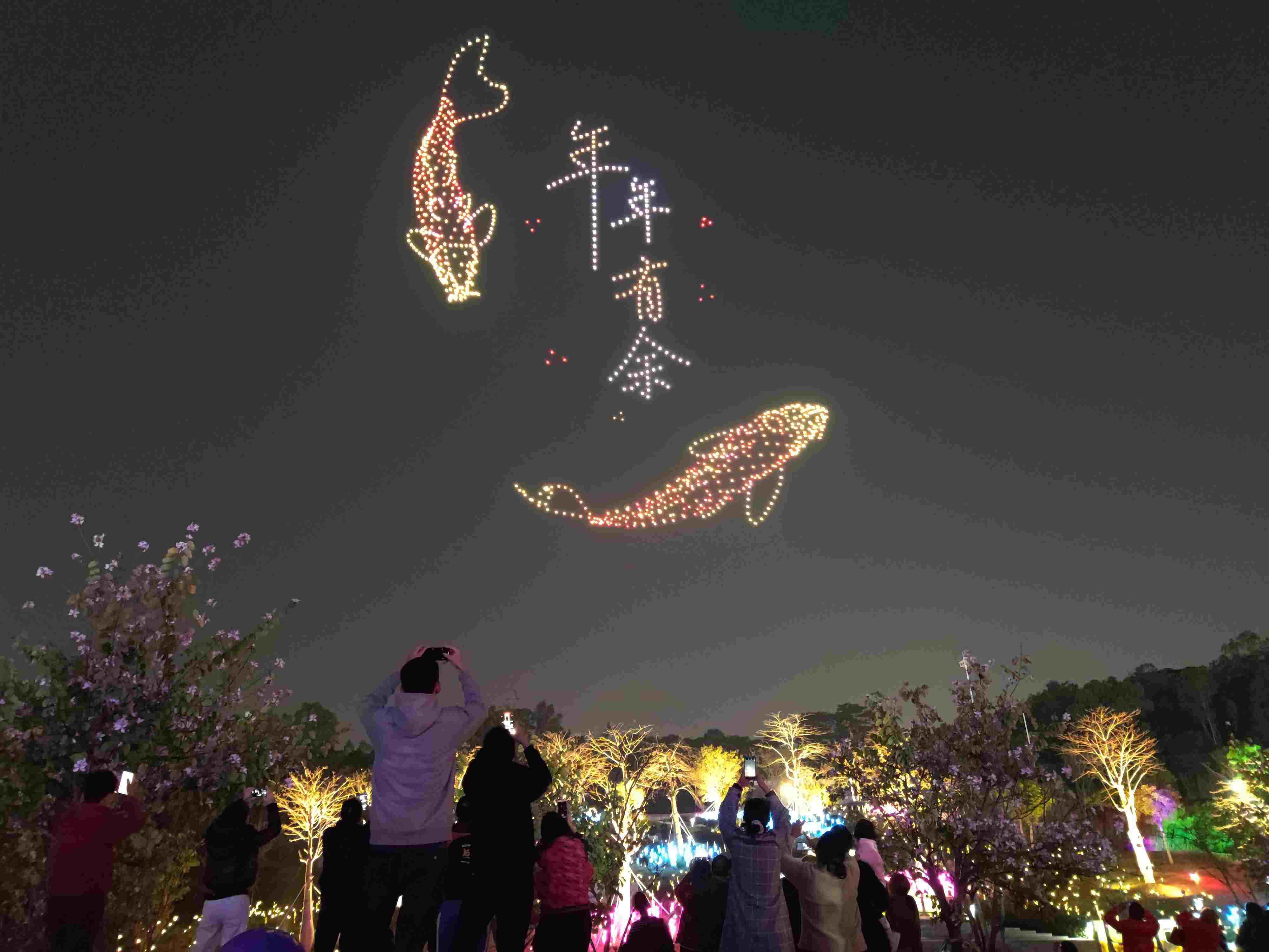 △ 2024年2月10日，深圳北站中心公園，春節(jié)主題無人機(jī)燈光秀引來眾多游客駐足觀看。
