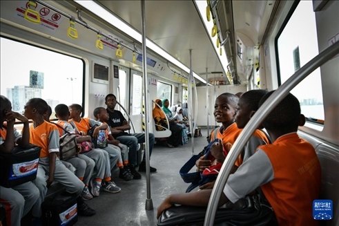 2月28日，在尼日利亞拉各斯，一所小學(xué)的學(xué)生們體驗(yàn)乘坐輕軌藍(lán)線(xiàn)列車(chē)。新華社記者 韓旭 攝