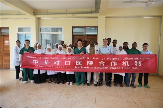 醫(yī)療隊(duì)隊(duì)員和當(dāng)?shù)蒯t(yī)生們合影。中國(guó)援桑醫(yī)療隊(duì)供圖