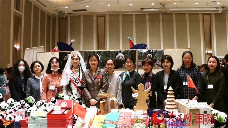 中國駐日本大使吳江浩夫人丁玥（左五）與使館人員在展位前合影留念。人民網(wǎng) 許可攝