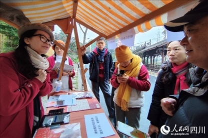 1月6日，“2024成都蒲江柑甜采摘節(jié)”上，記者見到了小萌（左一）和許多年輕人忙著做訪客接待、現(xiàn)場布置、票務(wù)核對、采摘服務(wù)等工作。人民網(wǎng)記者朱虹攝