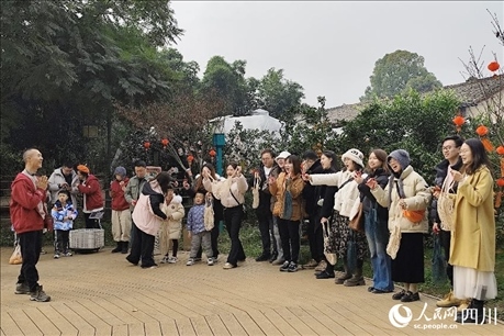 葉科（左一）給前來參與活動的“柑爸柑媽”介紹生態(tài)種植果。人民網(wǎng)記者朱虹攝