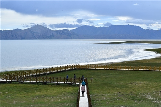 △ 游客行走在青?，敹嗫h冬格措納湖畔的木棧道上。